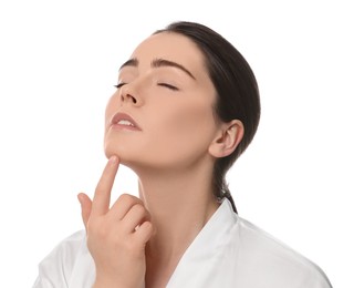 Young woman massaging her face on white background