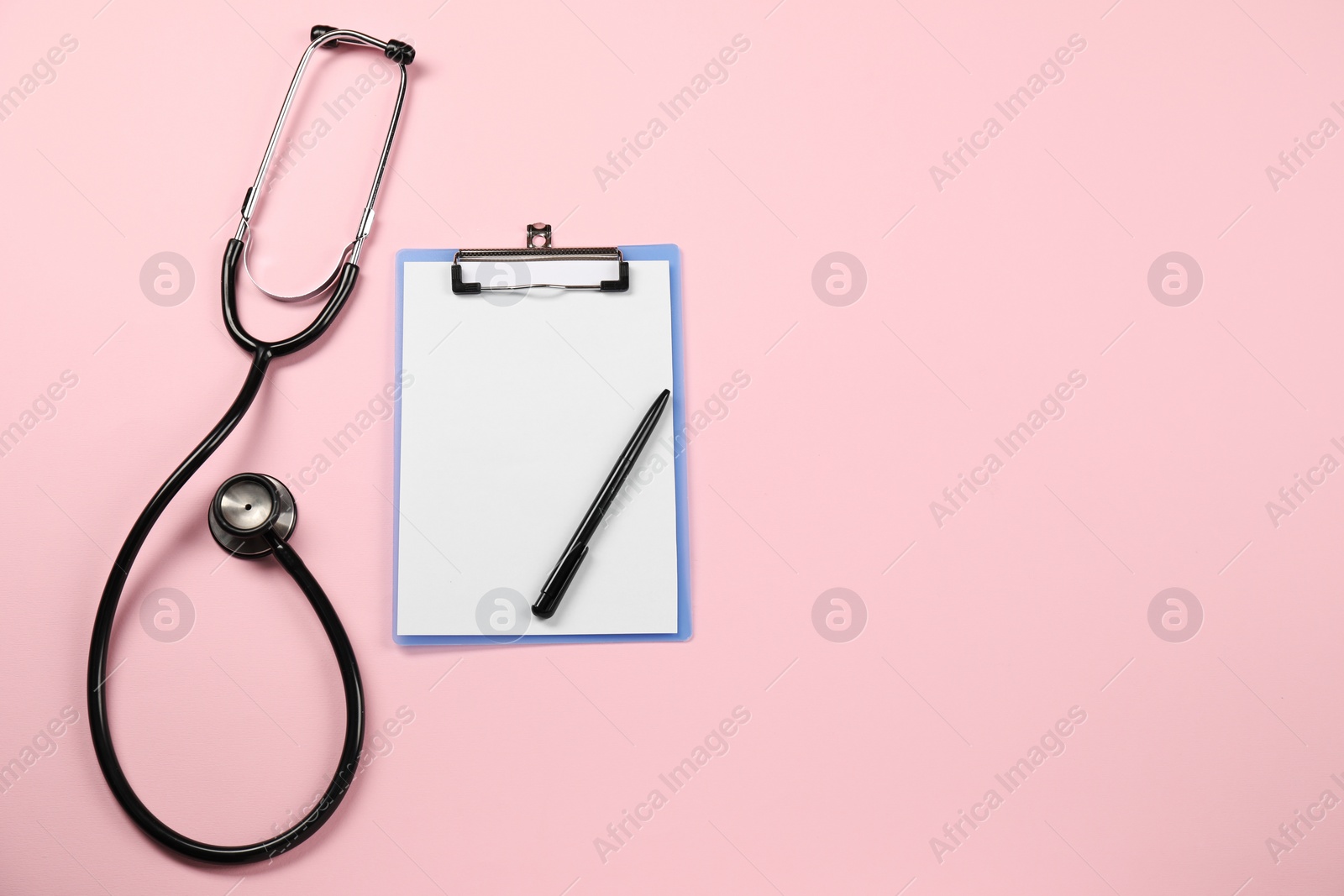 Photo of Endocrinology. Stethoscope, clipboard and pen on pink background, top view. Space for text