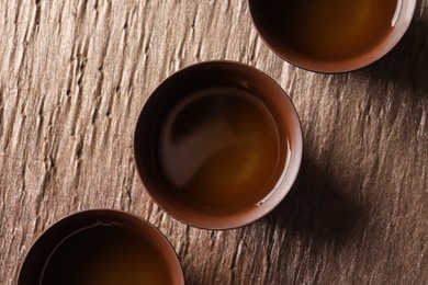 Photo of Cups of Tie Guan Yin oolong tea on table, top view