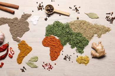 World map of different spices and products on wooden table, flat lay