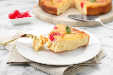 Photo of Eating piece of delicious pineapple pie with cherry and mint on white marble table, closeup