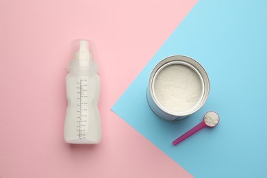 Feeding bottle with infant formula and powder on color background, flat lay