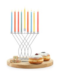 Photo of Hanukkah celebration. Menorah with colorful candles, dreidels and donuts isolated on white