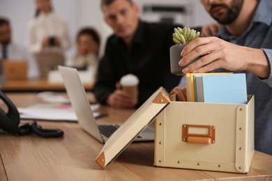 Photo of Dismissed man packing stuff into box at office, closeup. Space for text