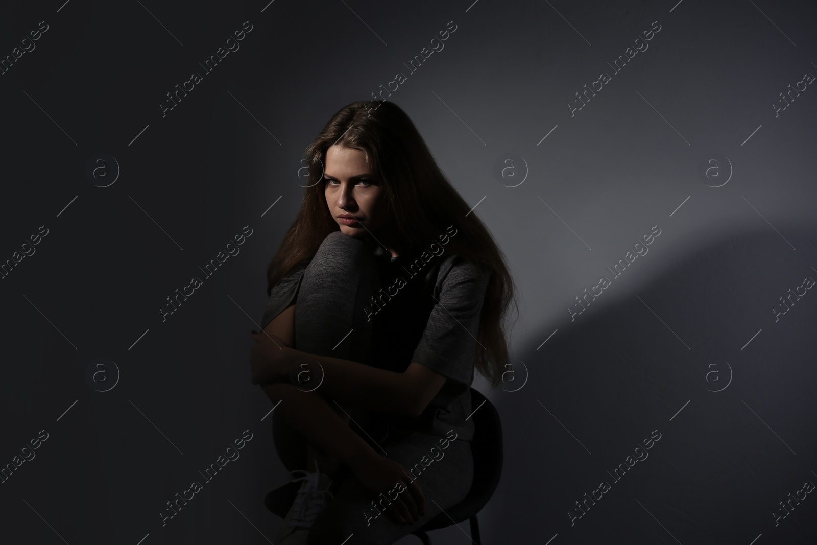 Photo of Depressed young woman on gray background