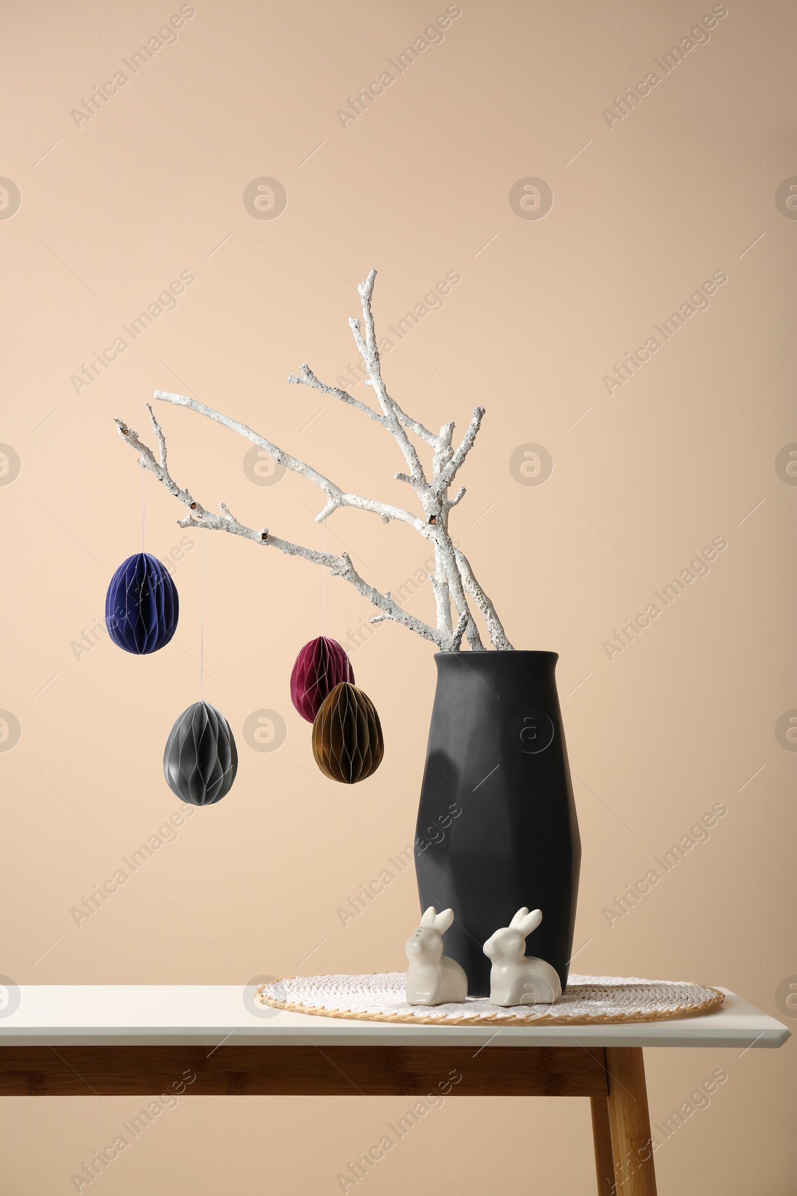 Photo of Beautiful festive composition with Easter decor on white table against beige background