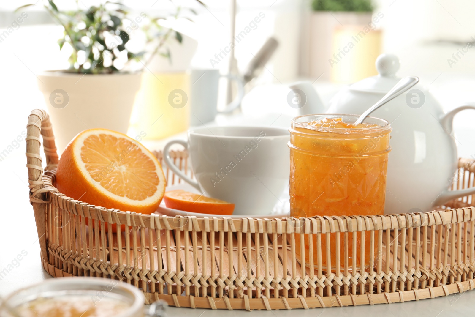 Photo of Delicious orange marmalade served with tea for breakfast in tray