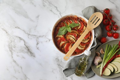 Photo of Delicious ratatouille and ingredients on white marble table, flat lay. Space for text