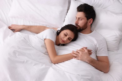 Photo of Lovely couple sleeping together in bed at home, top view