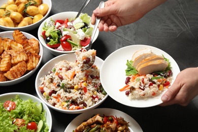 Photo of Woman taking food from buffet table, closeup