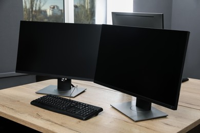 Photo of Modern interior. Workplace with multi-monitor on wooden desk in office, space for text