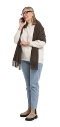 Senior woman with bag talking on smartphone against white background