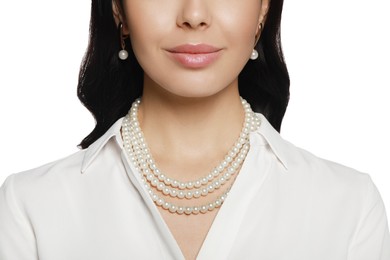 Photo of Young woman wearing elegant pearl jewelry on white background, closeup