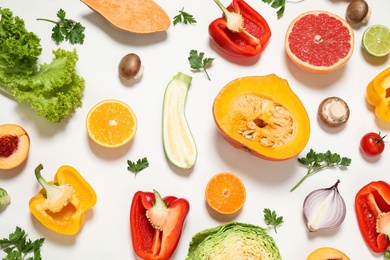 Fresh organic fruits and vegetables on white background, flat lay