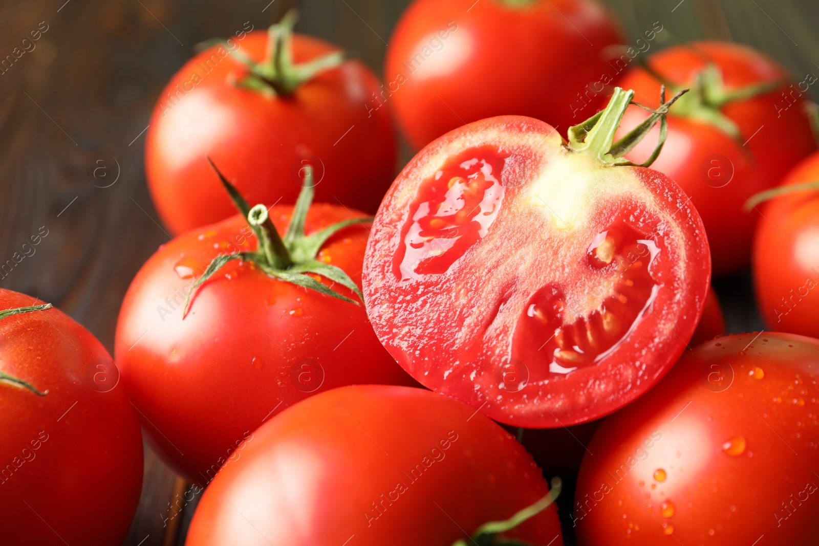 Photo of Fresh ripe tomatoes on wooden table, closeup