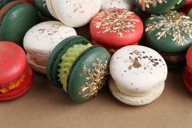 Beautifully decorated Christmas macarons on brown background, closeup