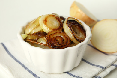 Photo of Tasty fried onion on napkin, closeup view