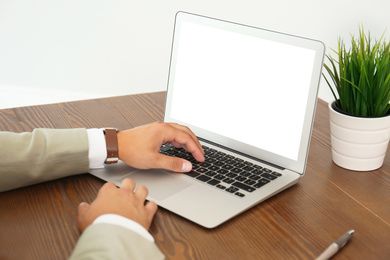 Young man using modern computer at table indoors, closeup. Space for design