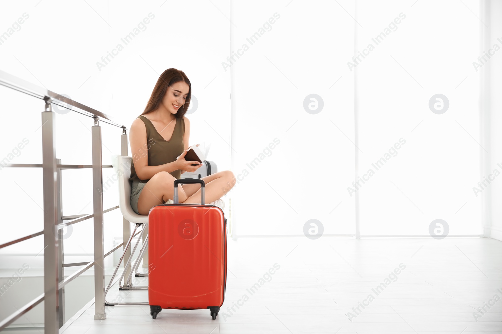 Photo of Young woman with suitcase in airport