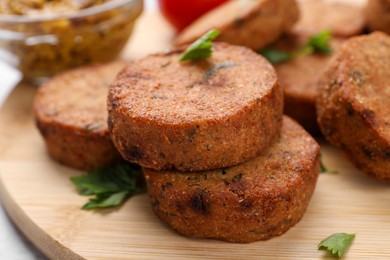 Tasty vegan cutlets on wooden board, closeup