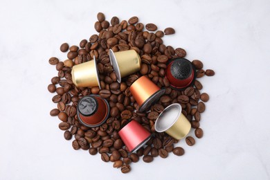 Photo of Many coffee capsules and beans on white background, top view