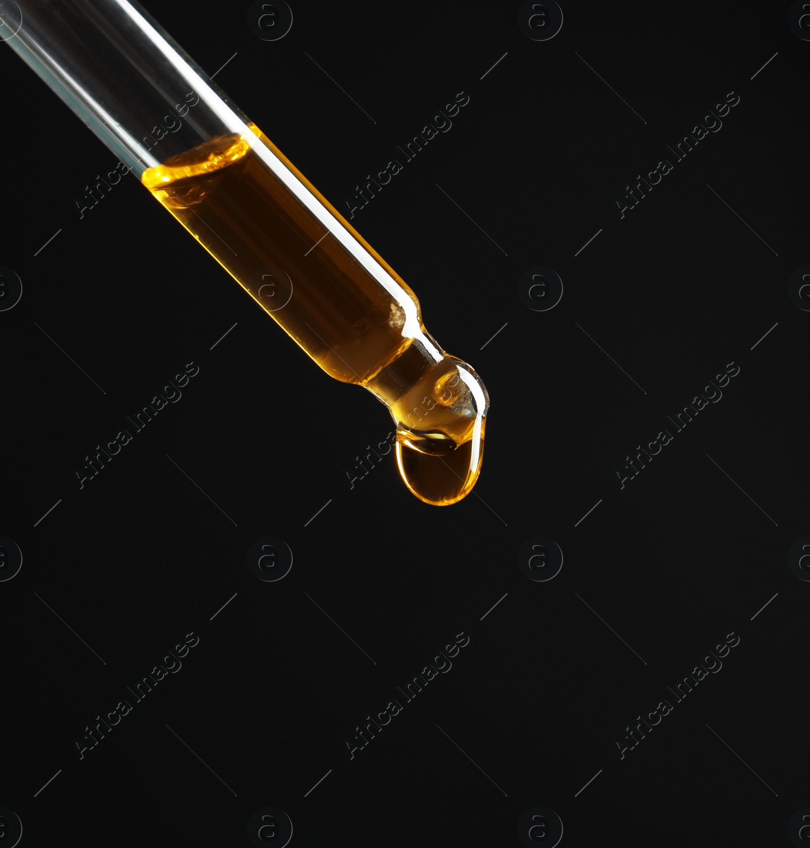 Photo of Pipette with essential oil on black background. Space for text