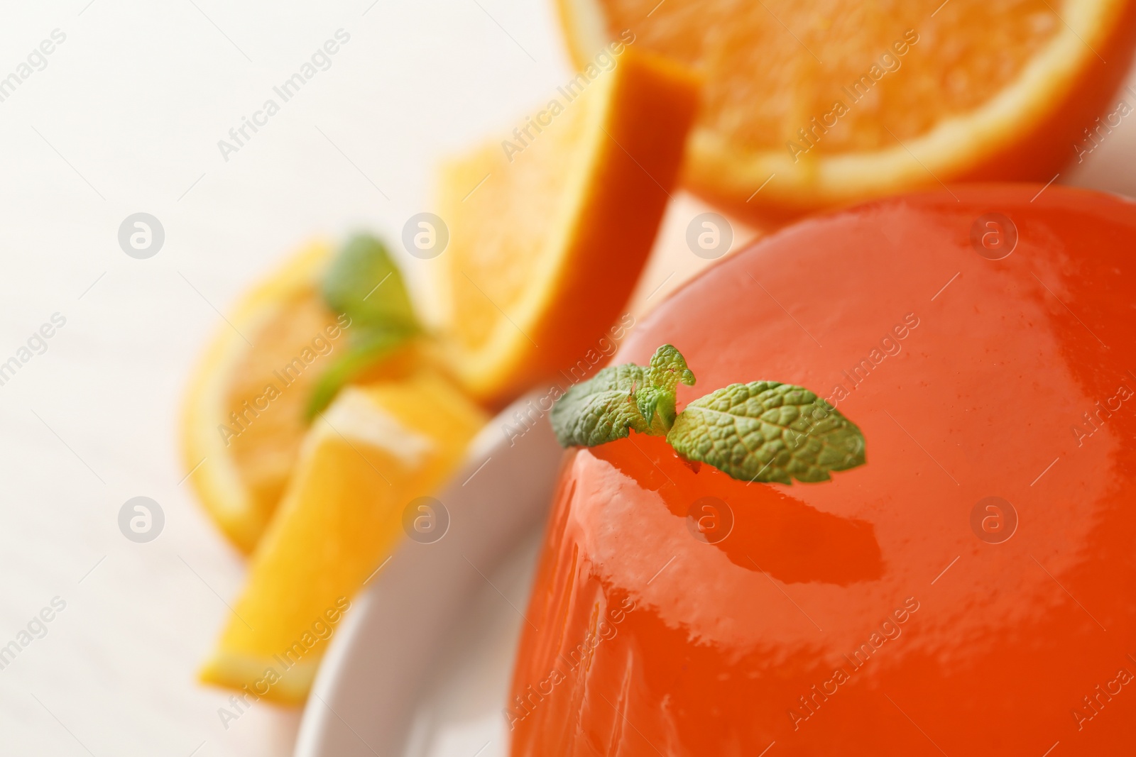 Photo of Tasty orange jelly with mint on table, closeup. Space for text