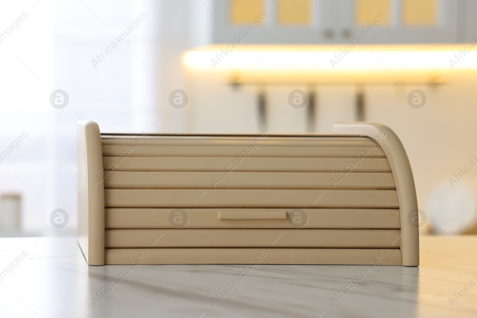 Photo of Wooden bread box on white marble table in kitchen