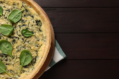 Delicious homemade spinach pie on wooden table, top view. Space for text