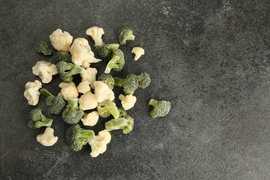 Frozen broccoli and cauliflower on gray table, top view. Space for text