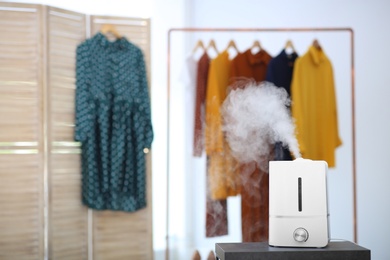 Modern air humidifier on table indoors. Space for text