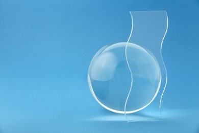 Photo of Composition with transparent glass ball on blue background. Space for text