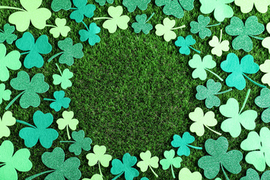 Frame made of clover leaves on green grass, flat lay with space for text. St. Patrick's Day celebration