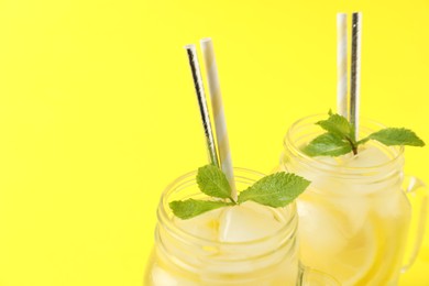 Photo of Natural freshly made lemonade with mint on yellow background, closeup. Summer refreshing drink
