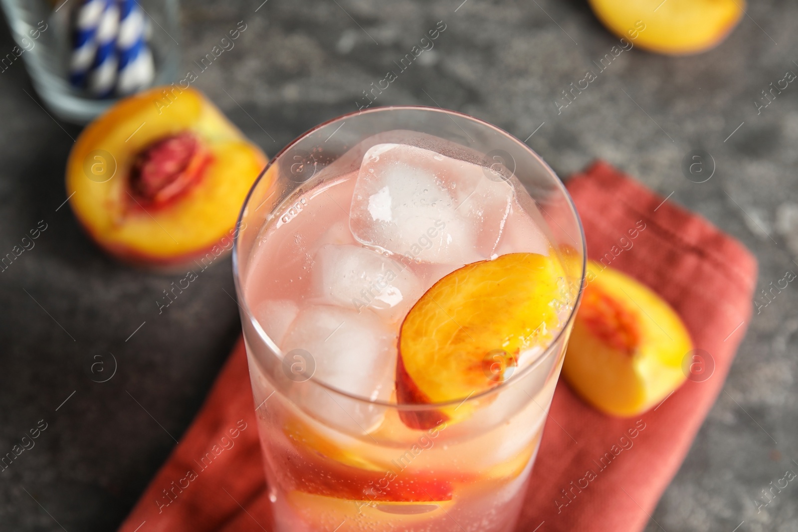 Photo of Tasty peach cocktail in glass on table, closeup. Refreshing drink