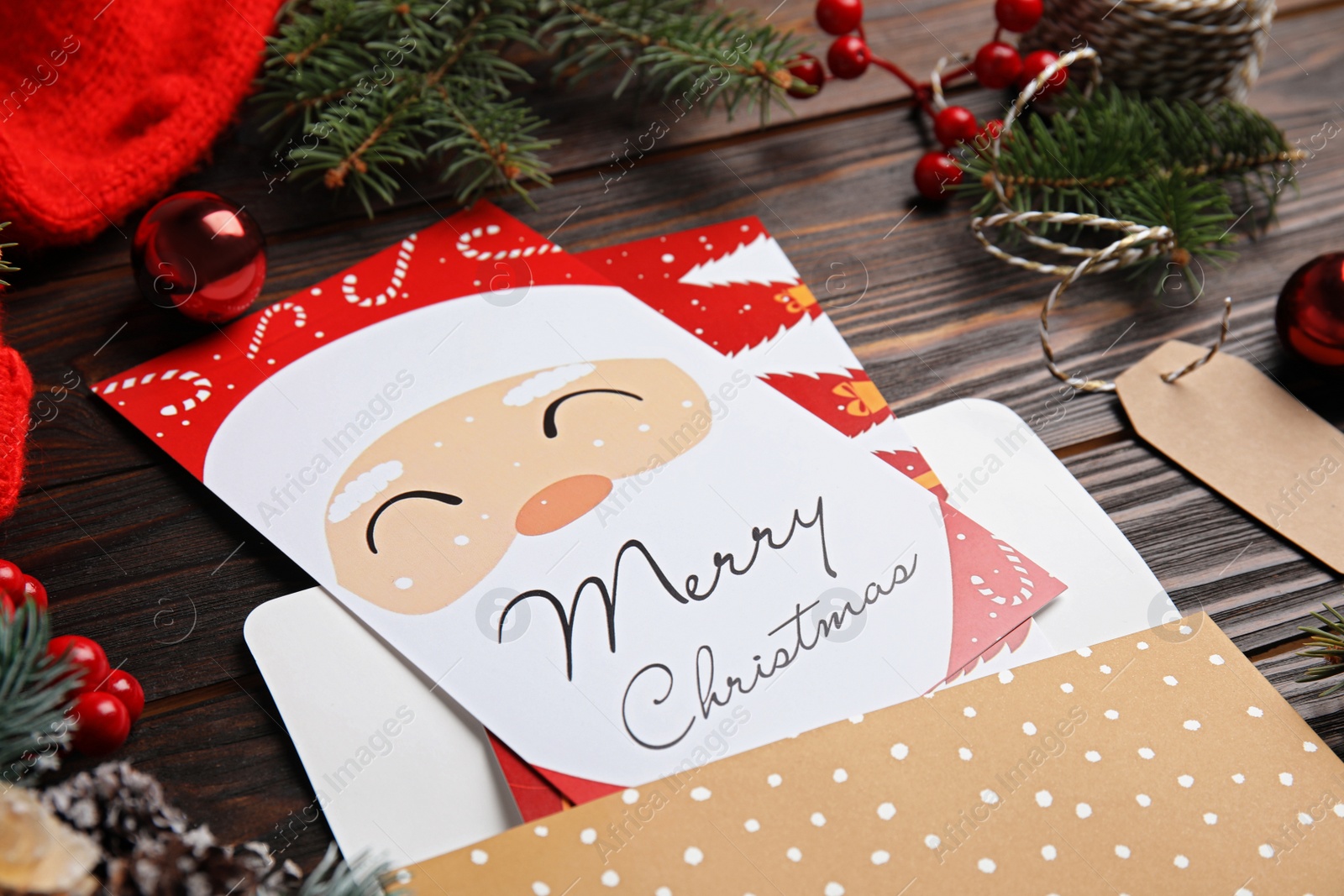 Photo of Christmas cards and festive decor on wooden background, closeup