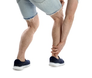 Young man suffering from leg pain on white background, closeup