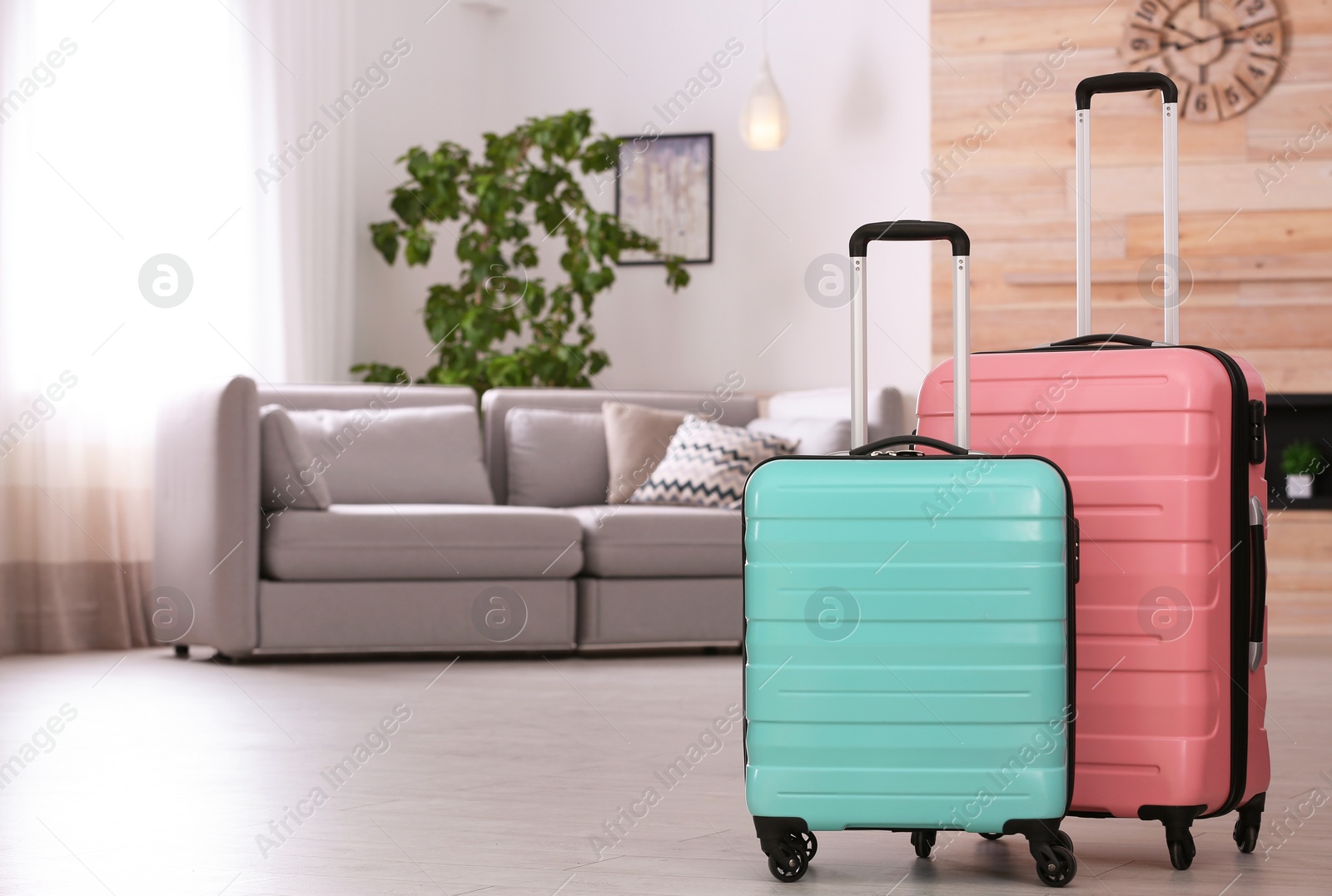 Photo of Colorful suitcases packed for journey in living room. Space for text