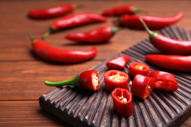 Photo of Fresh red chili peppers on wooden table