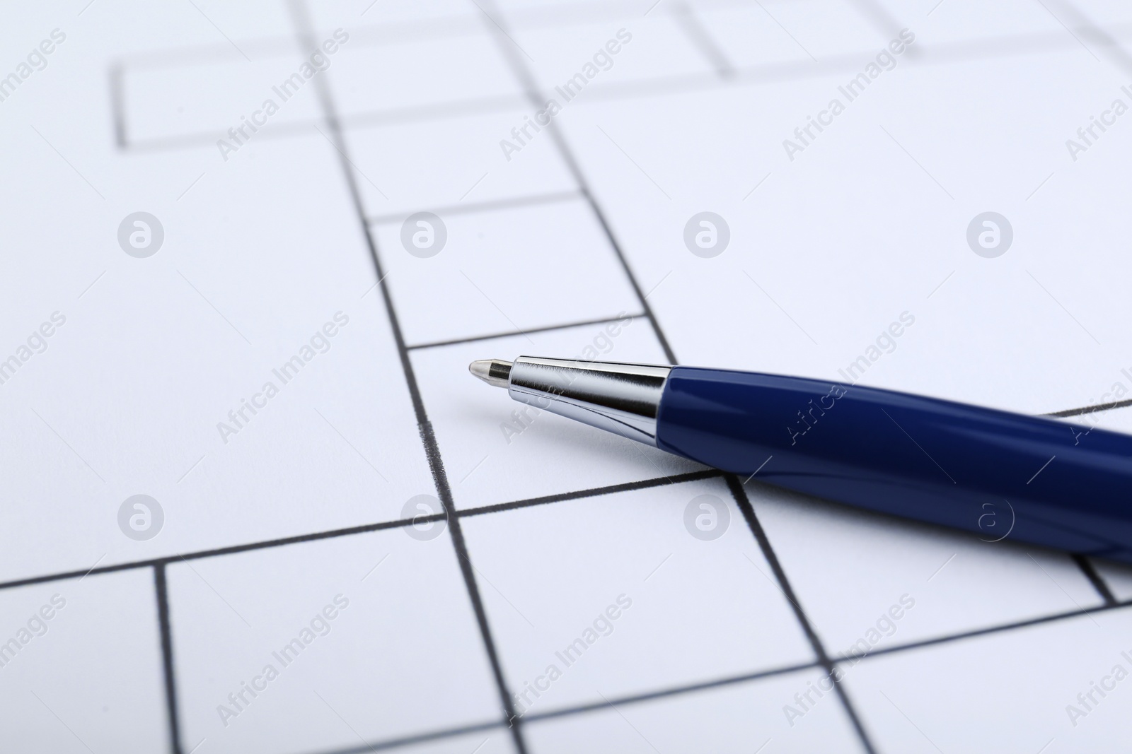 Photo of Pen and blank crossword, closeup. Space for text