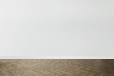 Image of Wooden floor and empty white wall indoors