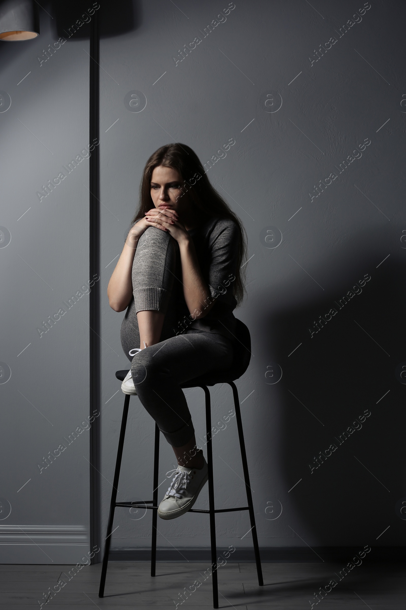 Photo of Depressed young woman on gray background