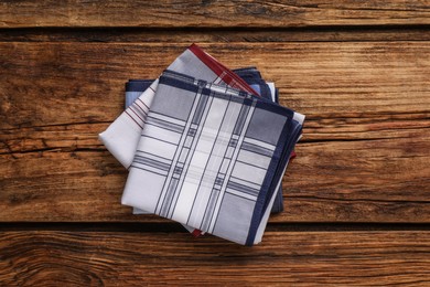 Different handkerchiefs folded on wooden table, top view