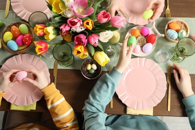 Photo of Festive table setting. Women celebrating Easter at home, top view