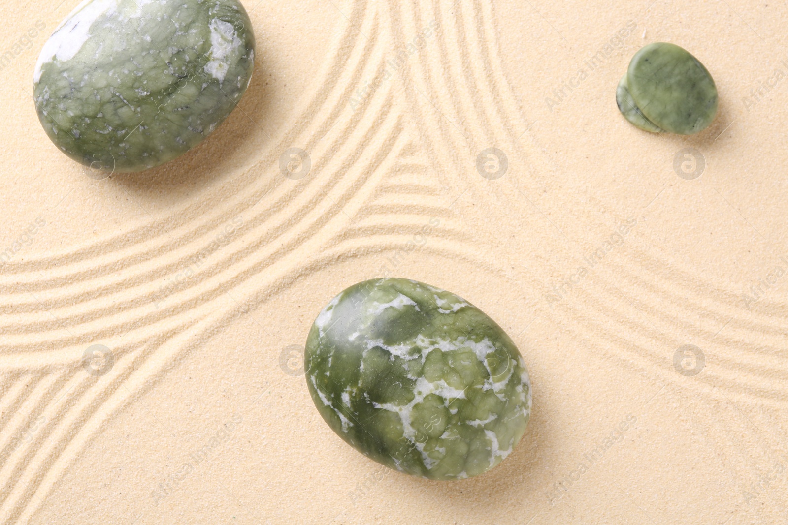 Photo of Zen concept. Stones and pattern on beige sand, flat lay