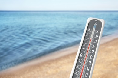 Weather thermometer and beautiful seashore. Heat stroke warning