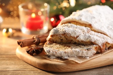 Photo of Traditional Christmas Stollen with icing sugar on wooden table