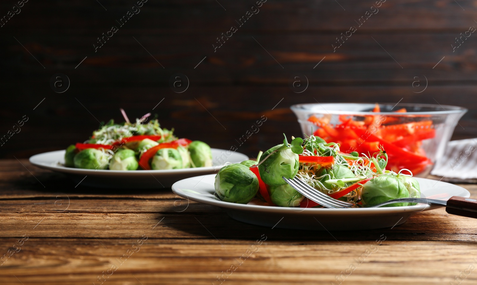 Photo of Tasty salad with Brussels sprouts served on wooden table