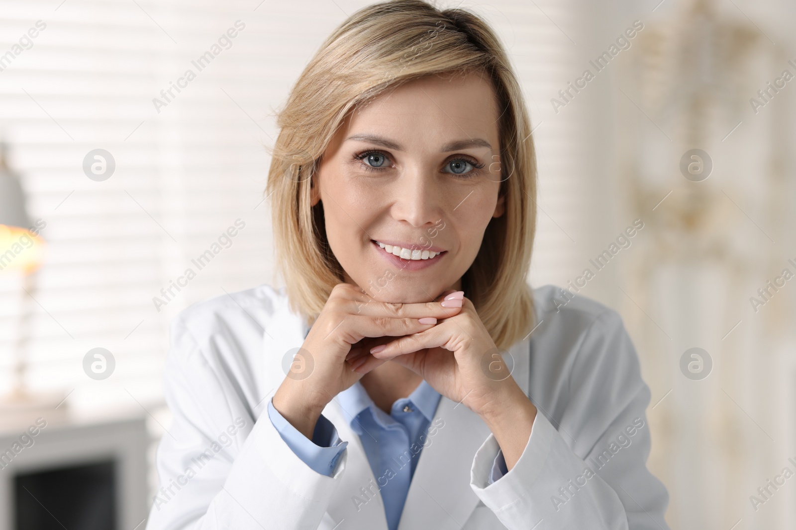 Photo of Portrait of smiling doctor on blurred background