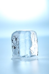 Photo of Cube of clear ice on light blue background